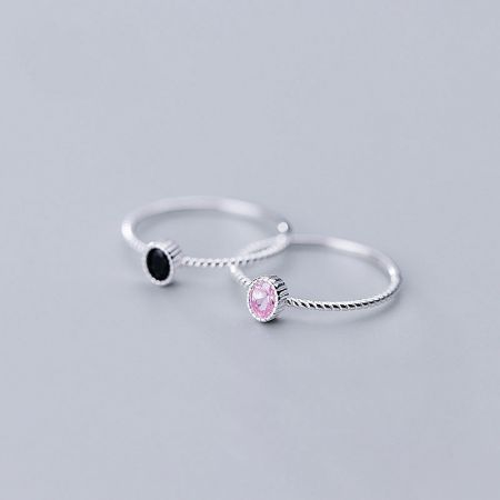 Top-down view of the sterling silver rings with pink and black cubic zirconia stones.