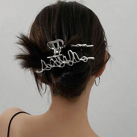 A model showcasing the large silver geometric hair clip in her hair.