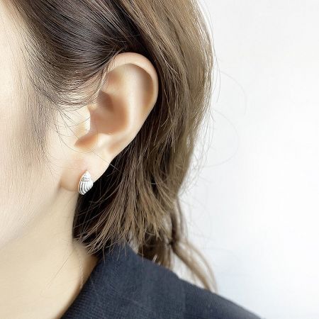 Model wearing the sterling silver seashell conch stud earring to show scale and style.