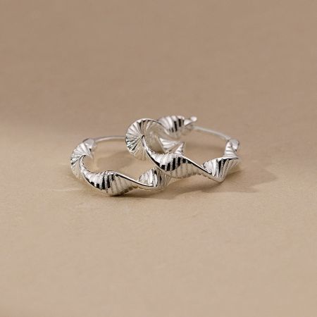 A pair of sterling silver hoop earrings with a unique wavy, shell-like texture.