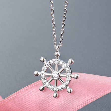 Detailed close-up of the silver ship's wheel pendant, highlighting the intricate stone settings and polished 925 sterling silver.