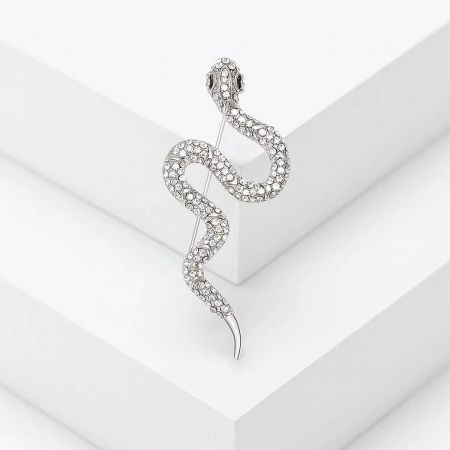 Creative Rhinestone Snake Brooch – Fashionable Minimalist Animal Pin - A close-up of the silver, snake-shaped brooch, intricately encrusted with sparkling clear gemstones, displayed on a white surface.