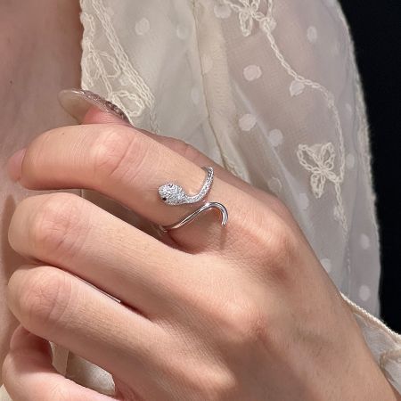 A woman wearing the sterling silver snake ring with a diamond-studded head on her index finger.