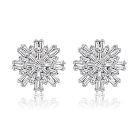 Star Flake Statement Earrings - A pair of silver Star Flake Statement Earrings in a snowflake design, featuring a central round cubic zirconia and surrounding baguette-cut stones on a white background.