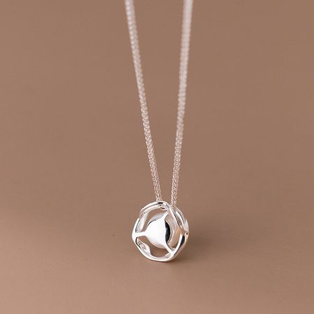 Detailed shot of the spherical pearl pendant, showcasing its smooth surface.