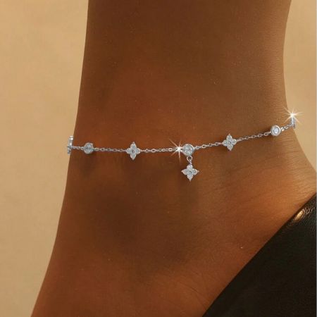 A model wearing the sterling silver clover anklet, a perfect accessory for summer outfits.