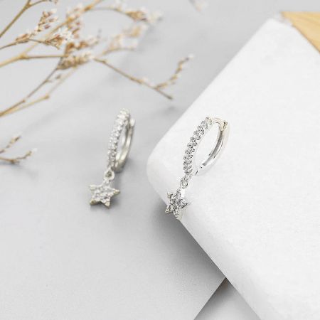 A pair of the silver star charm hoop earrings, displaying their elegant and minimalist design.
