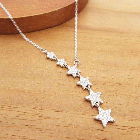 The sterling silver star necklace displayed on a neutral background.