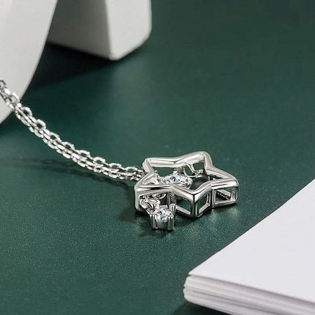 A detailed view of the geometric star pendant design with clear gemstones.