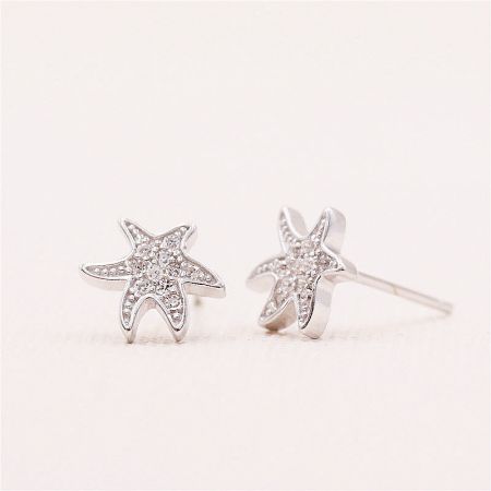 A close-up view of the silver starfish-shaped earrings, highlighting the sparkling clear gemstones.