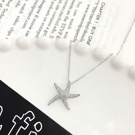 Detailed close-up of the 925 sterling silver starfish pendant with pave CZ stones.
