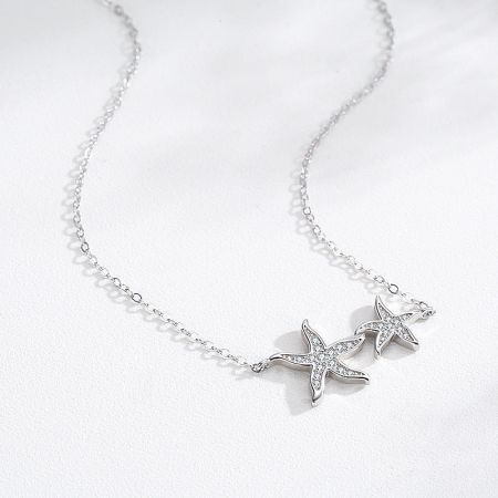 A styled shot of the silver starfish necklace with two pendants, emphasizing its elegant and charming design.
