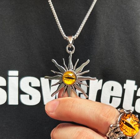 Close-up of the Evil Eye Sunburst pendant alongside a matching ring, showcasing the detailed craftsmanship.