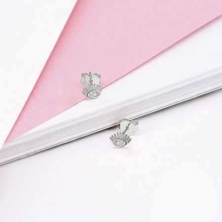 Close-up of a pair of sterling silver sunburst stud earrings, intricately detailed with clear zircon gemstones.