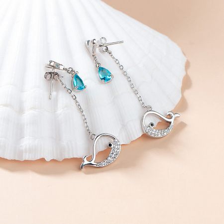 Elegant sterling silver drop earrings with blue and white gemstones on a seashell display.