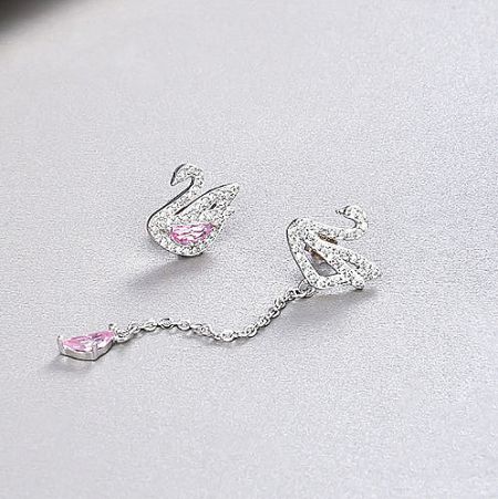 Asymmetrical design of the silver swan earrings, one stud and one drop earring with a pink gemstone.