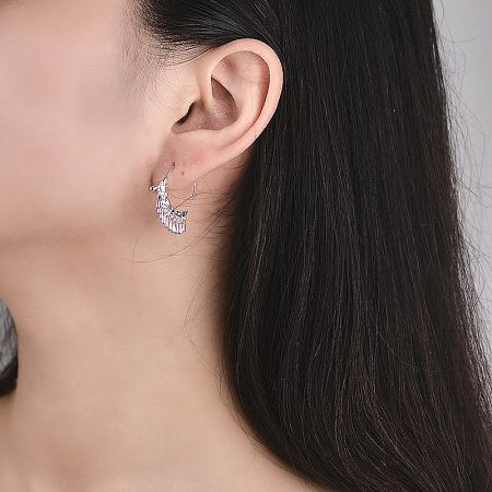 Detailed shot of the silver tassel earring on a model's ear.