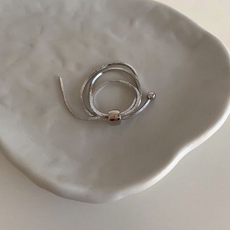 The silver adjustable chain ring with a textured finish, displayed on a marble surface.