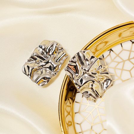 A pair of silver chunky rectangle stud earrings with a unique textured surface.