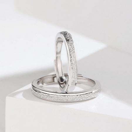 A detailed view of the sterling silver couple rings, highlighting their textured surface and adjustable band design.