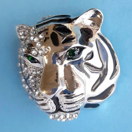 Angled shot of the tiger head brooch, showcasing the sparkle of the rhinestones and the vibrant green eyes.