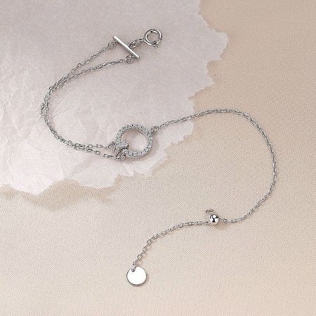 Close-up of the silver bracelet's toggle clasp and geometric pendant, showcasing the fine craftsmanship.