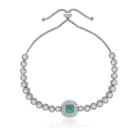 Glitter Adjustable Tennis Bracelet - A close-up of the Glitter Adjustable Tennis Bracelet, showcasing the central green cubic zirconia stone surrounded by clear stones in a silver-toned rhodium plated setting.