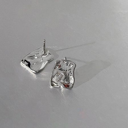 A pair of silver-plated stud earrings with a distinctive tooth-like shape.