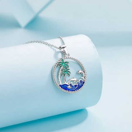 Sterling silver pendant showcasing a beach scene with a palm tree and waves.