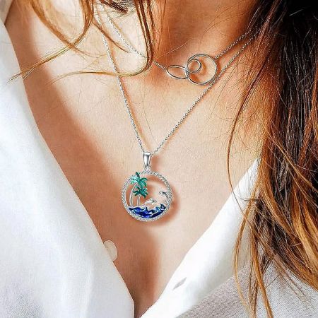 Close-up view of the tropical scene pendant on its silver chain.
