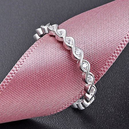 The petite twist band stackable ring shown on a neutral background.