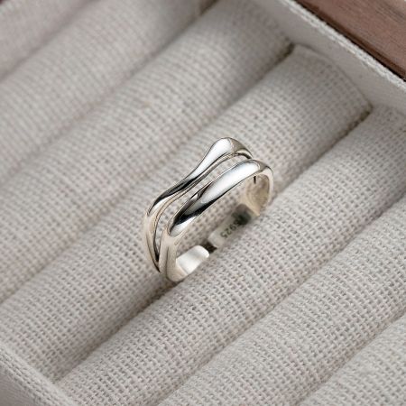 The double-layered sterling silver wave ring presented in a white jewelry box.