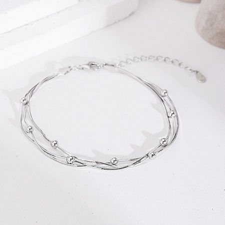 Close-up of the twisted layers and spherical beads of the 925 silver bracelet.