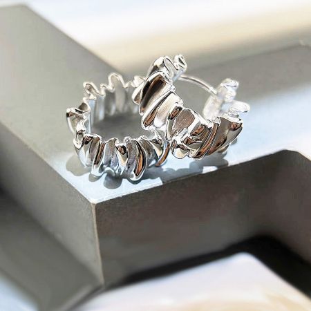 The 925 sterling silver pleated hoop earrings presented elegantly on a white jewelry box.