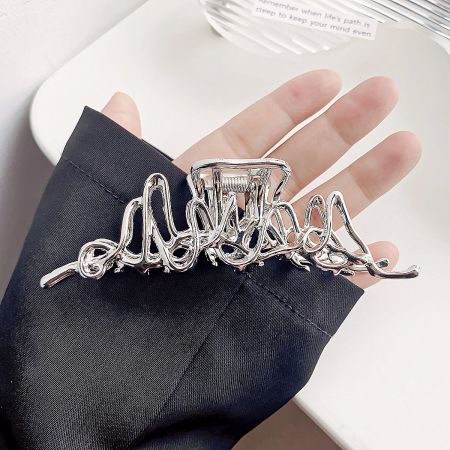 Close-up of the silver wavy design hair clip.