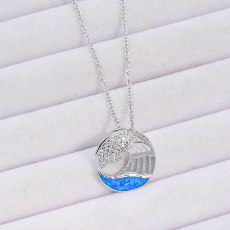 The wave pendant showcasing the contrast between clear stones and blue glitter details.