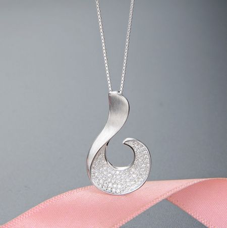 Close-up view of the silver wave pendant necklace adorned with sparkling cubic zirconia gemstones.