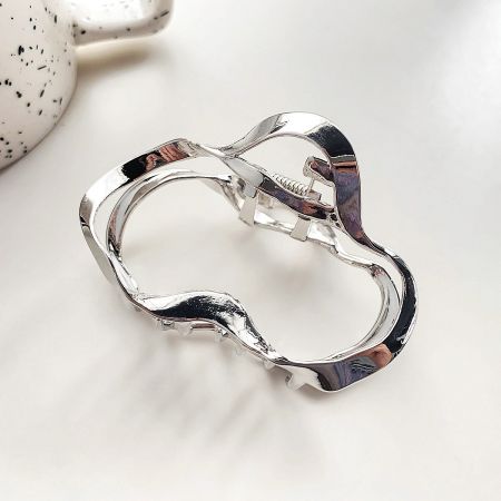 Detailed view of a single silver wavy hair clip, showcasing its unique shape.