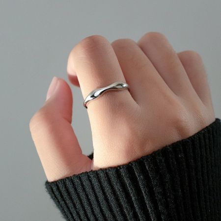 A model wearing the slim wavy sterling silver stackable ring to showcase its fit and style.