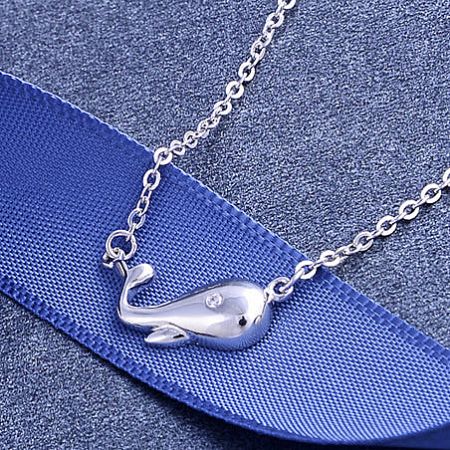 Close-up view of the sterling silver whale pendant.