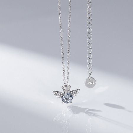 A silver winged heart pendant necklace with clear gemstones, part of the 5-piece set.