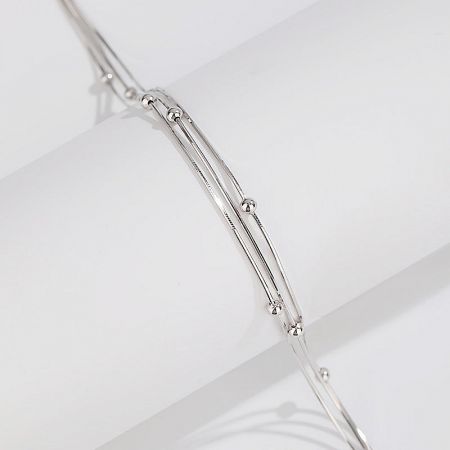 Macro view highlighting the unique wire and bead design of the silver jewelry piece.