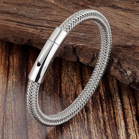 Side view of the silver woven bracelet, highlighting its intricate design on a driftwood background.