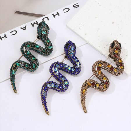 Metal Crystal Rhinestone Snake Brooch Pins (Set of 5) - A collection of three exquisite snake-shaped brooch pins in blue, green, and brown, each adorned with sparkling rhinestones, displayed on a neutral background.