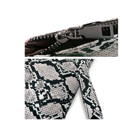 Close-up detail of the metallic zipper on the snakeskin pattern clutch bag.