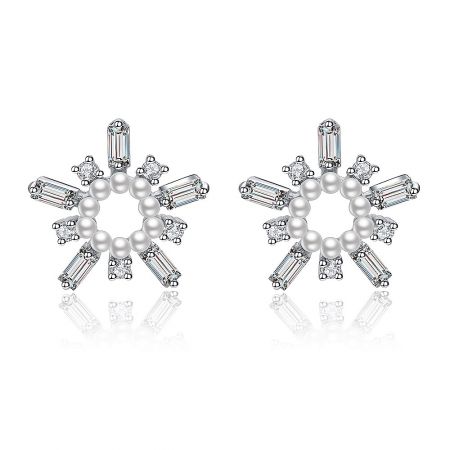 White As Snow Pearl Earrings - A close-up of the White As Snow Pearl Earrings, showcasing the intricate snowflake design with a central white pearl and sparkling cubic zirconia stones on a white background.