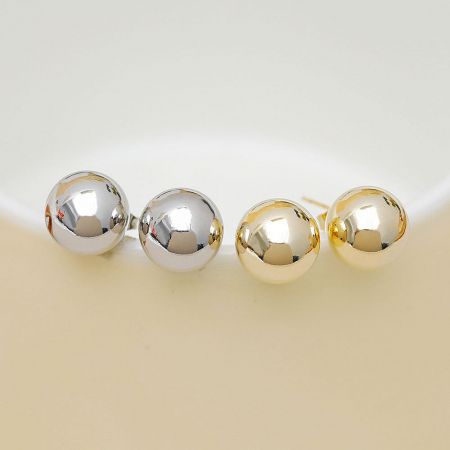 Top-down view of the gold and silver spherical stud earrings, showcasing their polished finish.