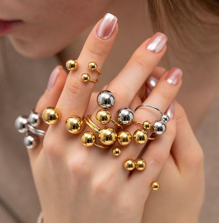 A model wearing multiple gold and silver stainless steel ball rings.
