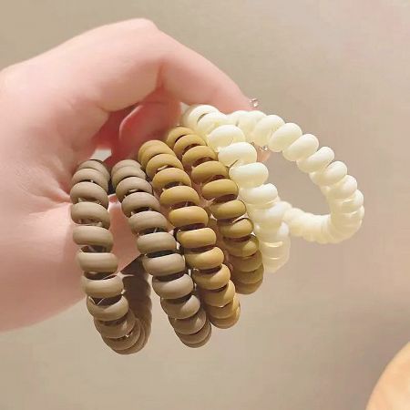 Close-up of brown and white telephone cord hair ties.
