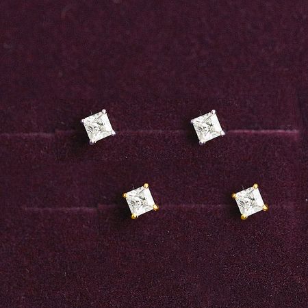 An assortment of square CZ stud earrings in both silver and gold finishes displayed on velvet.